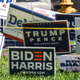 Trump-Pence and Biden-Harris signs are displayed outside The Coral Gables Branch Library in Miami, Florida on October 27, 2020.